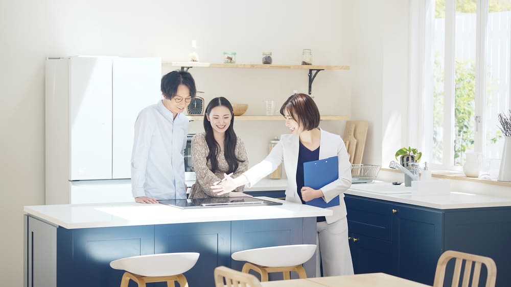 マンスリー物件の備え付き家電を紹介する女性
